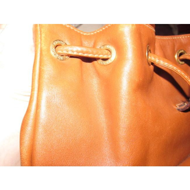 Gucci caramel brown colored leather, two strap, petite, drawstring top, multi-pocket, messenger bag/backpackk